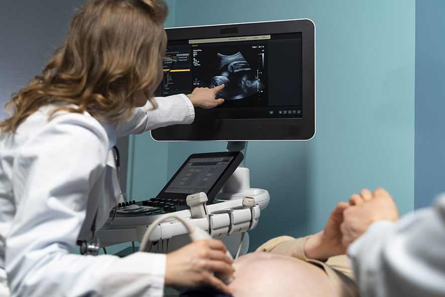 sage-femme réalisant une échographie pour une femme enceinte