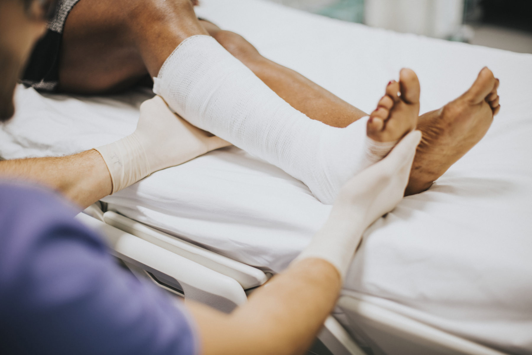Orthopédiste auscultant la cheville fracturée d'un patient