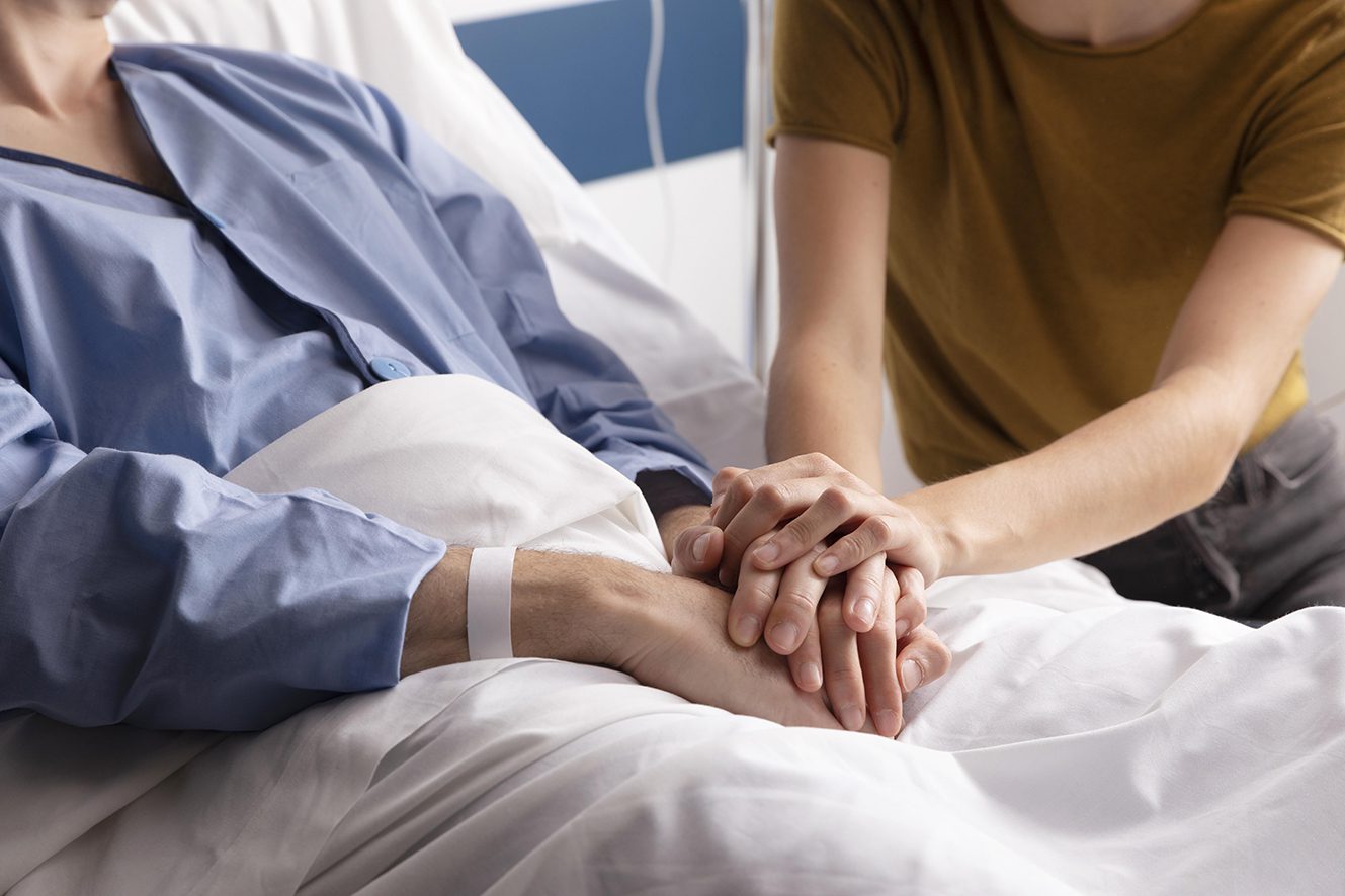 Femme tenant les mains de son mari hospitalisé