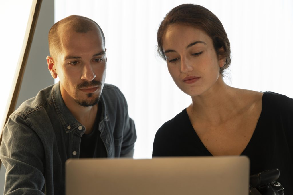 Homme et femme réalisant des recherche sur ordinateur