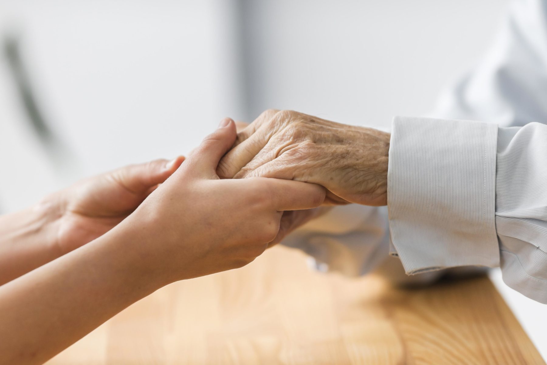 infirmière-tient-mains-personnes-agees